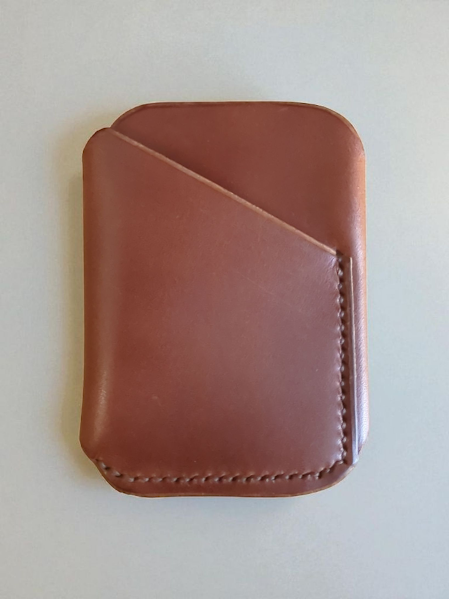 Brown leather cardholder on a light beige background