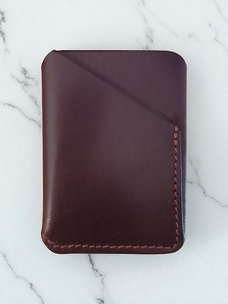 maroon leather wallet on a marble surface
