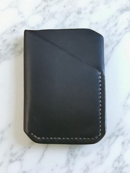 Black leather wallet on a marble surface