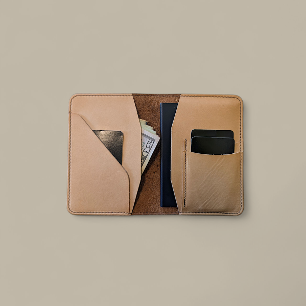 Open tan leather wallet with card slots and cash pocket on a beige background